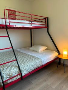 ein Schlafzimmer mit zwei Etagenbetten und einem Tisch in der Unterkunft Vakantiewoning Bisonder in Bilzen