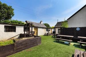 a backyard with a picnic table and benches at The Tavern in Buchlyvie