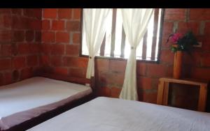 a bedroom with two beds and a window at Posada El Encanto in Nuquí