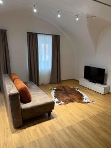 a living room with a couch and a flat screen tv at Hotel Gasthof Sonne in Aschach an der Donau