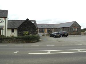 two cars parked in a parking lot next to a building at The Harp at Letterston in Letterston