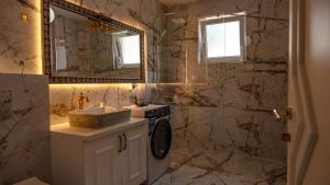 a bathroom with a sink and a washing machine at Lux Stays in Prishtinë +2 photos
