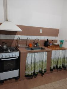 a kitchen with a stove and a sink at Alquiler Ramos in Viedma