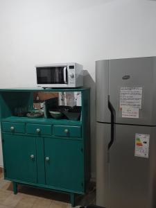 a microwave on top of a cabinet next to a refrigerator at Alquiler Ramos in Viedma