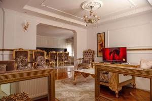 a living room with chairs and a couch and a television at Lux Stays in Prishtinë
