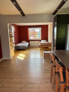 a kitchen and living room with red walls and wooden floors at Vila in Hultsfred