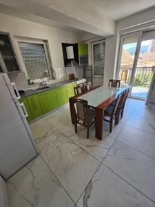 a kitchen and dining room with a table and chairs at XXL APARTMENTS CiTY CENTAR 1 in Bitola