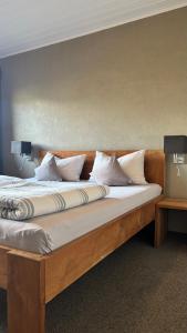 a large wooden bed with white pillows on it at Pension Hauenstein in Lagundo