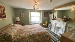 a bedroom with a bed and a fireplace and a window at Market House 17th Century Boutique B&B in Wincanton