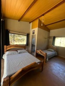 a bedroom with two beds and a window at Chale3 Rabodegalo in Santana do Riacho