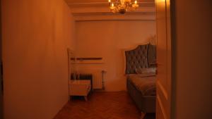 a small bedroom with a bed and a chandelier at Lux Stays in Prishtinë