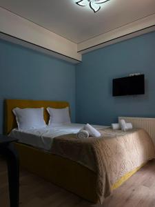 a bedroom with a bed with a tv on the wall at G&G დასასვენებელი სახლი in Tsaghveri