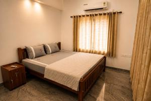 a bedroom with a large bed with a window at Hridyas in Ernakulam