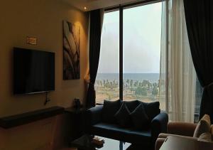 a living room with a couch and a large window at المهاجر للشقق المخدومة بالكورنيش in Jeddah