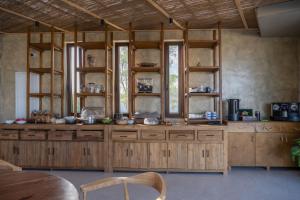 a large kitchen with wooden cabinets and windows at Glaronissi Beach in Plaka