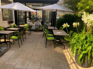 an outdoor patio with tables and chairs and umbrellas at Hotel Atlanta Knokke in Knokke-Heist +73 photos