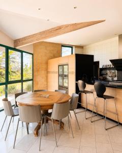 a kitchen and dining room with a wooden table and chairs at Villa Harmonie in Monteton +6 photos