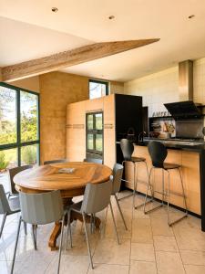 a kitchen with a wooden table and chairs at Villa Harmonie in Monteton