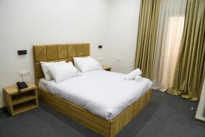 ein Schlafzimmer mit einem Bett mit weißen Laken und Kissen in der Unterkunft Cristam in Biskra