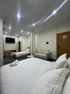 ein Schlafzimmer mit einem großen weißen Bett und einer Couch in der Unterkunft Cristam in Biskra