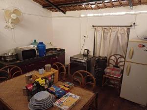 a kitchen with a table and a refrigerator at Home Stay in Arogyam at Mulshi Backwaters in Mulshi