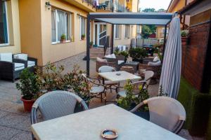 a patio with tables and chairs and an umbrella at Vila Cristal in Baile Felix
