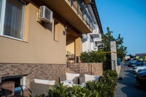 a patio with white chairs and a building at Vila Cristal in Baile Felix