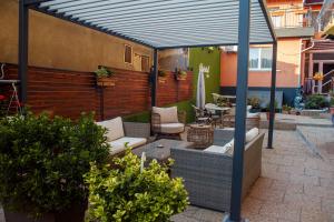a pergola with couches and chairs on a patio at Vila Cristal in Baile Felix +59 photos