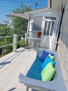 a chair on a deck with pillows and an umbrella at Casinha de Lamares in Vila Real