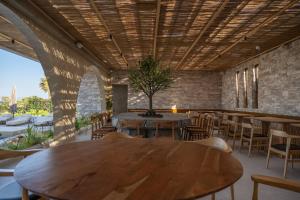 a dining room with tables and chairs and a tree at Glaronissi Beach in Plaka