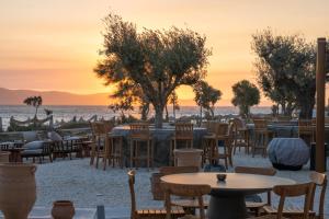 a restaurant on the beach with tables and chairs at Glaronissi Beach in Plaka +64 photos