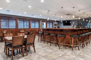 a dining room with a bar and chairs at Quality Inn Austintown-Youngstown West in Youngstown