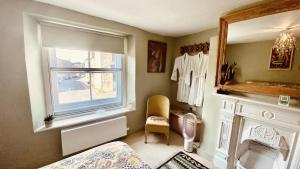 a bedroom with a bed and a window and a mirror at Market House 17th Century Boutique B&B in Wincanton