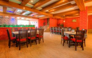 a dining room with tables and chairs and red walls at Treebo Trend Shivam Inn near Singapore Mall in Lucknow