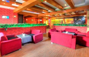 um restaurante com cadeiras vermelhas e uma parede de tijolos em Treebo Trend Shivam Inn Near Singapore Mall em Lucknow