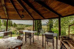 a patio with tables and chairs and a view at Agriturismo Quarantallina in Buonconvento