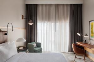 a bedroom with a bed and a chair and a desk at Hotel Verdant in Racine