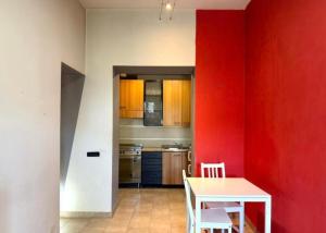 a kitchen with red walls and a table and chairs at Alloggio turistico Brancaleone in Genazzano