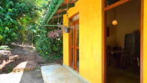 an entrance to a yellow house with a door at Kethbima Agri Cottage in Amunugama