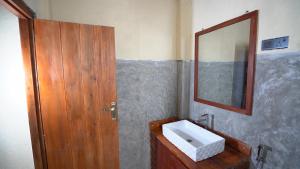 a bathroom with a sink and a mirror at Kethbima Agri Cottage in Amunugama