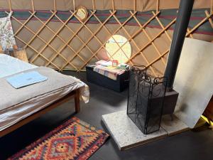 a room with a bed and a mirror in a yurt at Ash Yurt in Kent +9 photos