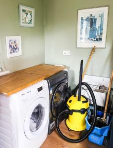 a washing machine with a vacuum cleaner next to it at Iona in Blessington
