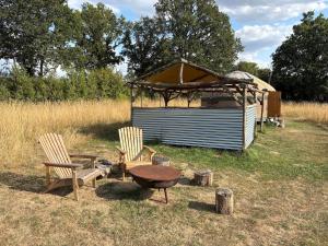 a gazebo and two chairs and a table in front of a house at Ash Yurt in Kent