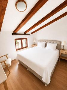 a bedroom with a large white bed and wooden floors at Apartments Micic in Lovran
