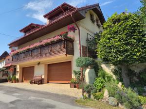 a house with a balcony with flowers on it at Apartmán Donovaly Mišuty 586 in Donovaly