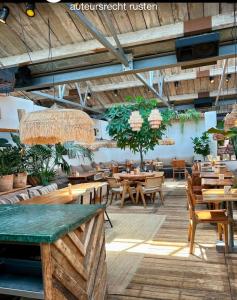 a restaurant with wooden tables and wooden chairs at Studio Casa Martine in Noordwijk aan Zee