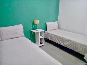 two beds in a room with a green wall at El Prado Chico, Casa de Campo in Salta