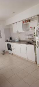 a kitchen with white cabinets and a white refrigerator at Departamento luminoso y amplio in San Antonio de Areco