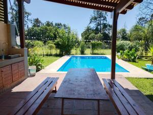 a swimming pool with a picnic table next to a patio at El Prado Chico, Casa de Campo in Salta