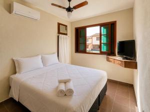 a bedroom with a bed with two towels on it at Hotel Canto do Rio Maresias in Maresias +23 photos